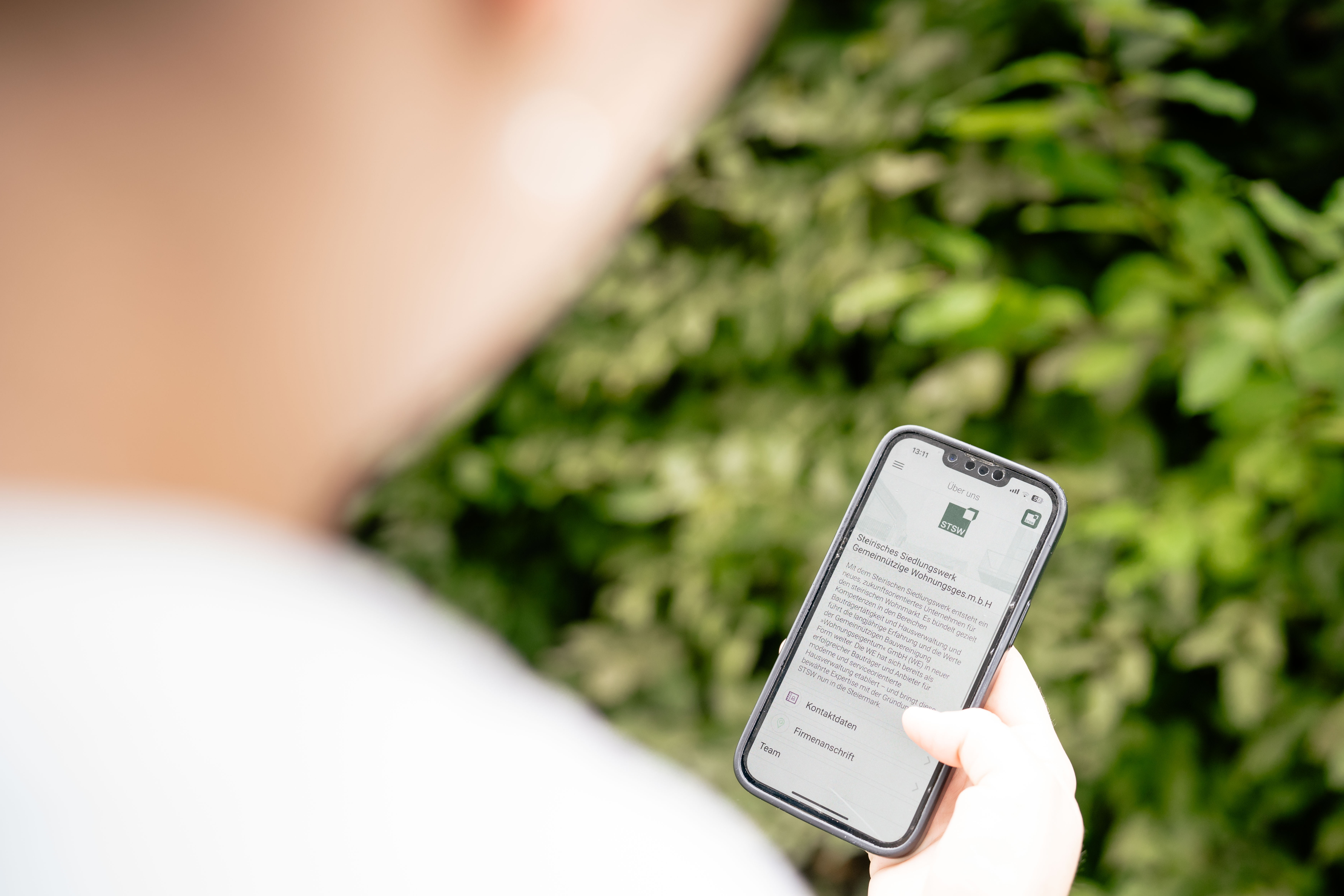 STSW-App_02 @ Fabian Hasler Frau schaut auf die STSW APP auf ihrem Smartphone
